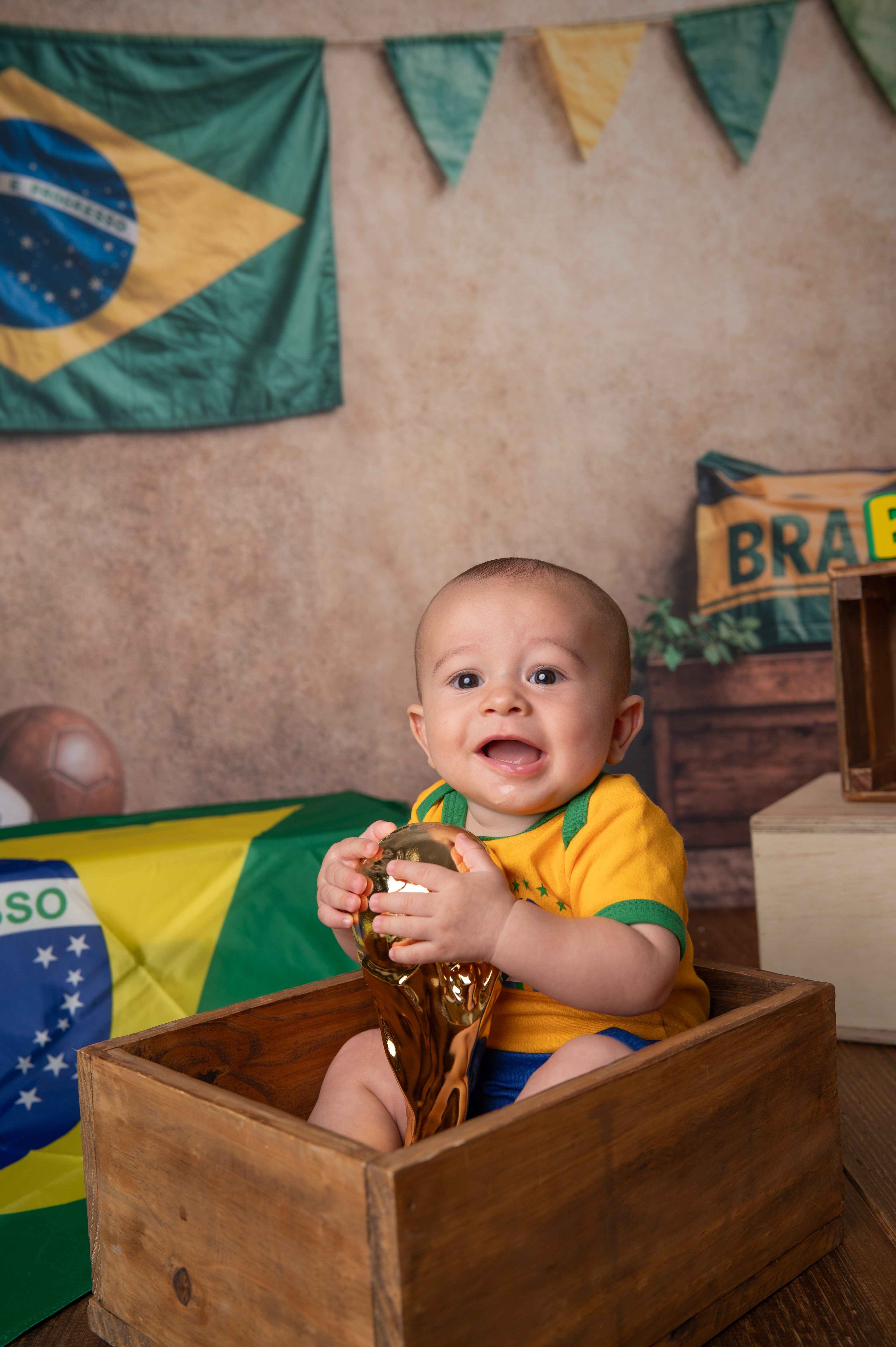 Bebê dentro de caixote segurando taça